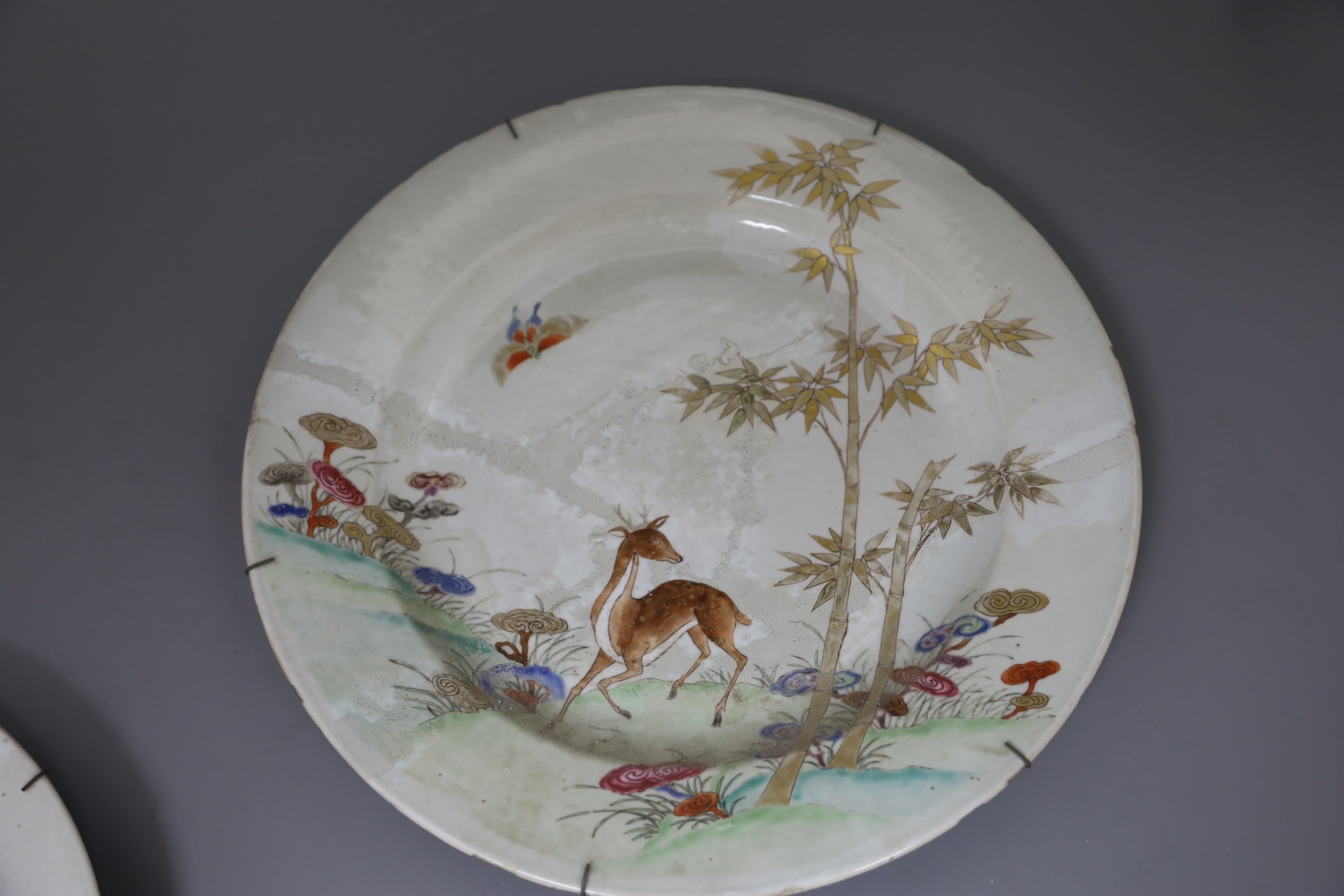 Three graduated Chinese famille rose deer, bamboo and lingzhi dishes, Qianlong period (1736-95), D. 26cm, 32cm and 38.5cm